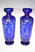 Pair of blue glass vases with enamelled floral decoration, 35cm high.