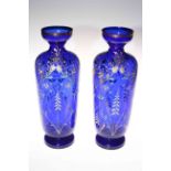 Pair of blue glass vases with enamelled floral decoration, 35cm high.