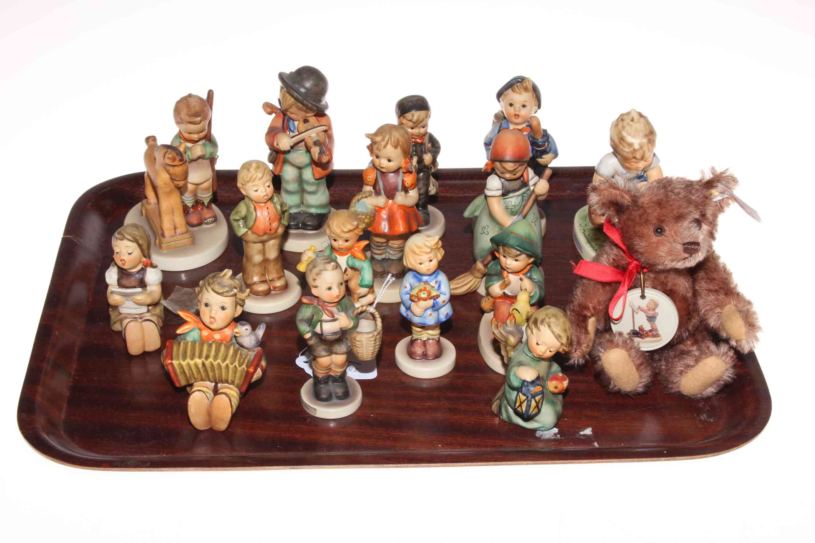 Collection of fifteen Hummel figures and Steiff teddy.