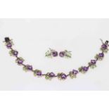 Silver bracelet and earrings with amethyst coloured stones and green enamel flowers.