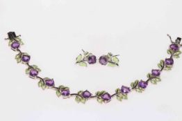 Silver bracelet and earrings with amethyst coloured stones and green enamel flowers.