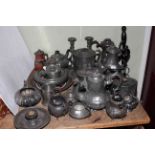 Collection of pewter including teapots, lidded jug, candlesticks, biscuit jar, etc.