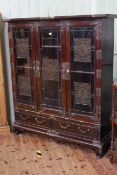 Chinese hardwood and brass mounted cabinet having three glazed doors with brass fretwork panels