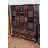 Chinese hardwood and brass mounted cabinet having three glazed doors with brass fretwork panels
