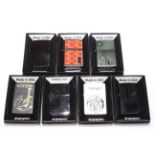 Seven boxed Zippo lighters.