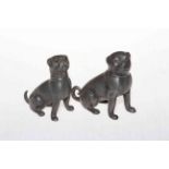 Two antique metal dog pepperettes with glass eyes.