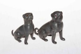 Two antique metal dog pepperettes with glass eyes.