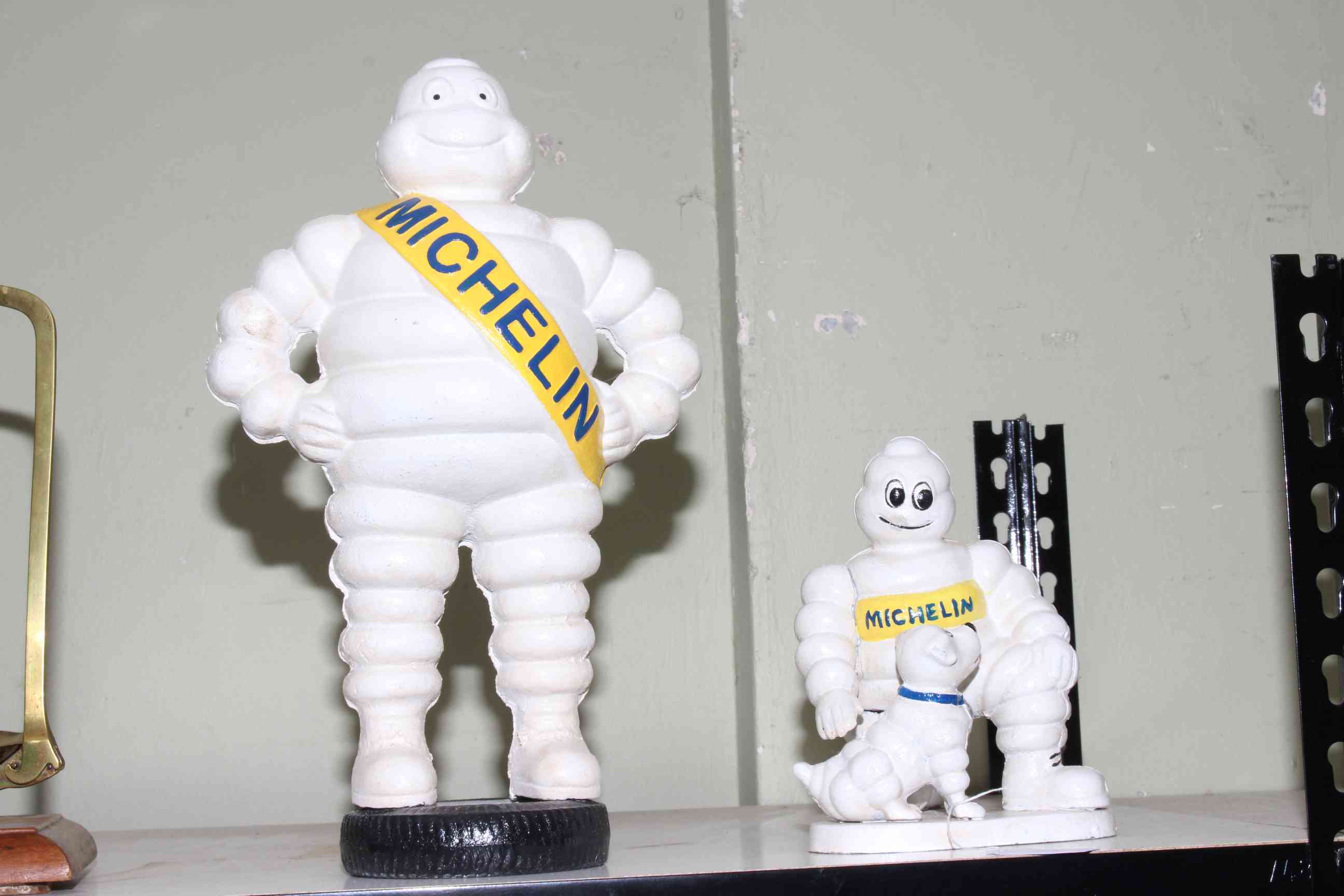 Two cast iron Michelin Men, 40cm and 22cm.