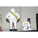 Two cast iron Michelin Men, 40cm and 22cm.