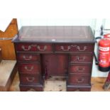 Mahogany eight drawer kneehole desk with central inset cupboard, 76cm by 91.5cm.
