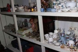 Full shelf of glass, china, brass and horse brasses, annuals, teddy, doll, etc.