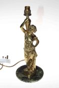 Ornate brass lamp modelled as a lady dressed in robes holding a jug, mounted on a stone plinth,