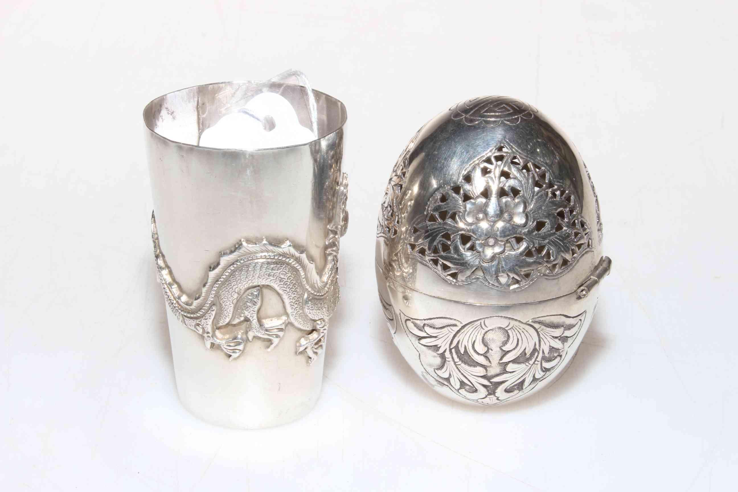 Chinese silver beaker with dragon decoration and a pierced silver egg (2).