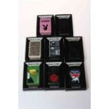 Eight boxed Zippo lighters.