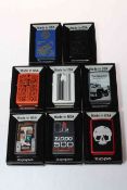 Eight boxed Zippo lighters.