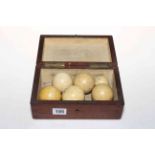 Six various ivory billiard balls in mahogany box.