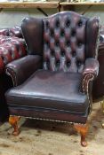 Button back leather wing armchair.