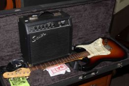 Vintage branded electric guitar with accessories in case, together with a Squier amplifier.