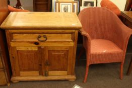 Pine side cabinet with frieze drawer above double door cupboard and Lloyd Loom bedroom chair.