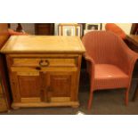 Pine side cabinet with frieze drawer above double door cupboard and Lloyd Loom bedroom chair.