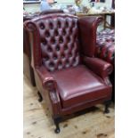 Red leather button back wing armchair.