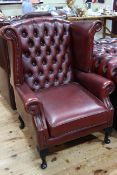 Red leather button back wing armchair.