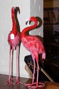 Two metal models of flamingos.