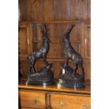 Pair of large impressive bronze stags on rocky outcrops, raised on marble plinths, 75cm high.