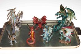 Collection of seven metal dragon ornaments.