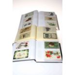 Three postcard albums housing vintage Christmas and New Year greetings postcards,