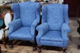 Two similar Edwardian wing armchairs on ball and claw legs.