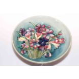 Moorcroft Pottery bowl decorated with spring flowers on green ground, 28cm diameter.