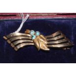 9 carat gold brooch set with three blue stones, 11.2g gross, boxed.