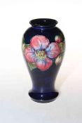 Moorcroft Pottery vase decorated with clematis on blue ground, 18cm high.