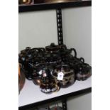 Ten floral Victorian black glazed teapots.