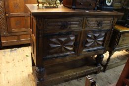 Carved oak buffet cabinet having two drawers above two cupboard doors and undershelf,