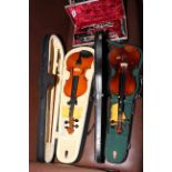 Cased oboe and two cased 3/4 violins with bows.