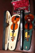Cased oboe and two cased 3/4 violins with bows.