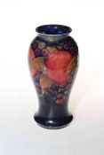 Moorcroft Pottery vase decorated with pomegranate on blue ground, 18cm high.
