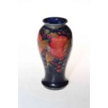 Moorcroft Pottery vase decorated with pomegranate on blue ground, 18cm high.