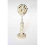 Chinese ivory reticulated ball on figure stand, overall 21cm.