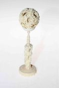 Chinese ivory reticulated ball on figure stand, overall 21cm.