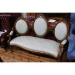 Victorian walnut triple oval panel back settee with serpentine front seat.