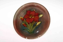 Moorcroft Pottery plate decorated with freesia on brown ground, 22cm diameter.