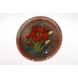 Moorcroft Pottery plate decorated with freesia on brown ground, 22cm diameter.