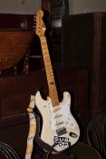 Cream electric guitar and stand.
