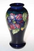 Large Moorcroft Pottery vase decorated with clematis on blue ground, 26cm high.