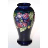 Large Moorcroft Pottery vase decorated with clematis on blue ground, 26cm high.