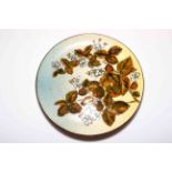 Chr. Dresser Linthorpe pottery plate decorated with overglaze enamel foliage, 29cm diameter.