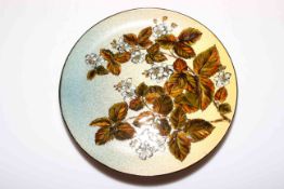 Chr. Dresser Linthorpe pottery plate decorated with overglaze enamel foliage, 29cm diameter.